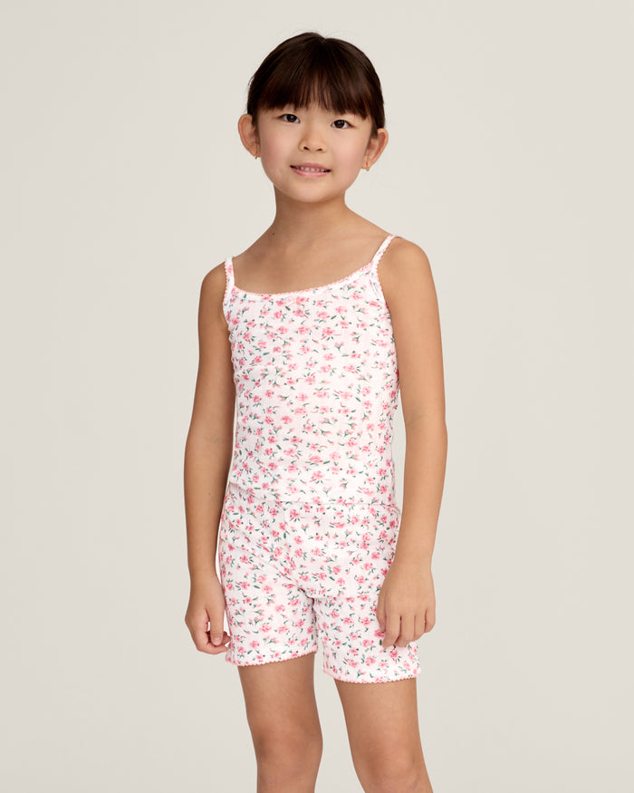 The Kid's Pointelle Cami Set of 2 in White & Pink Floral includes two sleeveless camisoles: one plain white with a bow and one white with a pink and green floral pattern. Both feature thin straps and lace trim.