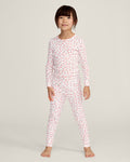 A young girl stands barefoot against a plain background, wearing the Kid's Pointelle Snug Fit Pajama Set in Pink Floral. She faces forward with a relaxed, neutral expression.