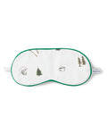 The Kids Sleep Mask in The Great Outdoors by Petite Plume features a white design with green trim, adorned with camping scenes like trees, a globe, a mug, and ski gear. PETITE is artfully displayed on the side strap—ideal for young adventurers who dream of the outdoors.