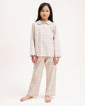 Kid's Twill Colette Pajama Set in Camel Gingham, featuring a beige and white gingham pattern with a scalloped collar, long sleeves, front pocket, and matching elastic-waist pants, is displayed neatly on a white background.