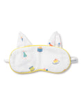 The Kids Twill Kitty Sleep Mask in Birthday Wishes by Petite Plume is a luxurious white eye mask with yellow trim, featuring colorful cake, party hat, and balloon illustrations. It includes two fabric ears, an elastic strap, and can be monogrammed for personalization.