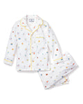 The Kids Twill Pajama Set in Birthday Wishes by Petite Plume is adorned with prints of small kitchen items like whisks, eggs, and pastries. This comfy classic set includes a top with a pocket and yellow piping, perfect for cozy relaxation.