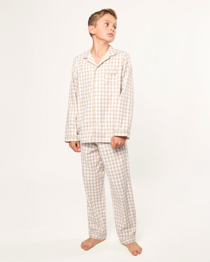 Kid's Twill Pajama Set in Camel Gingham features long sleeves, pants with an elastic waistband, and a button-up shirt with a collar and front pocket, all in a beige and white gingham check pattern.