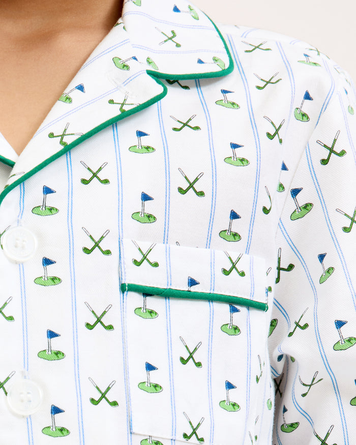 The Kid's Twill Pajama Set in Fairway Stripe features white pajamas with green piping, a tennis racket and green stripe pattern, a long-sleeve button-up top with a chest pocket, and matching long pants.