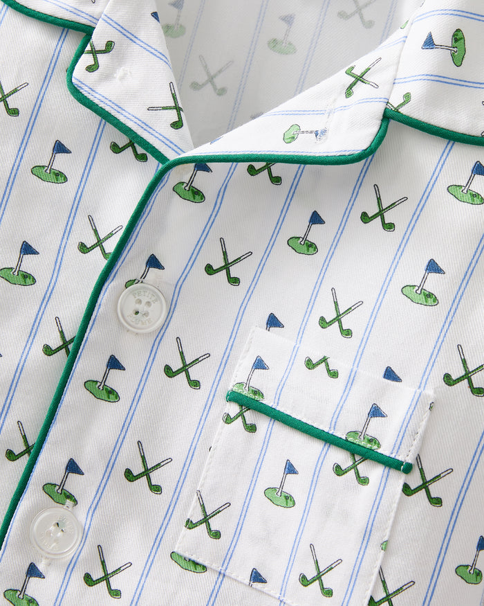 The Kid's Twill Pajama Set in Fairway Stripe features white pajamas with green piping, a tennis racket and green stripe pattern, a long-sleeve button-up top with a chest pocket, and matching long pants.