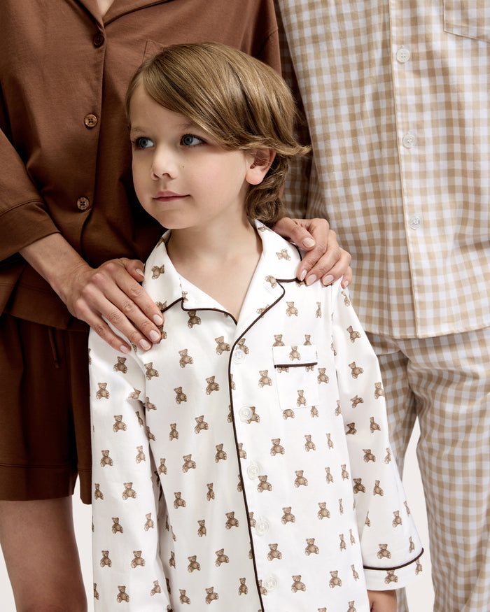 Kid's Twill Pajama Set in Teddy Tales: white long-sleeve, button-up pajamas with pants, featuring brown teddy bear print, dark piping along edges and chest pocket.