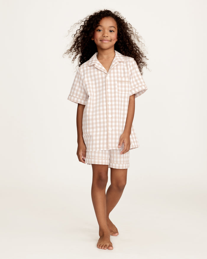 The Kid's Twill Pajama Short Set in Camel Gingham features a light beige and white gingham pattern with a collared, button-front top, chest pocket, and elastic waist shorts.