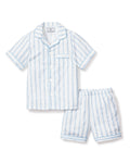 The Petite Plume Kids Twill Pajama Short Set in Periwinkle and White Stripe features soft, yarn-dyed cotton with a button-up shirt, chest pocket, and matching elastic-waist shorts in a light blue and white vertical stripe pattern.