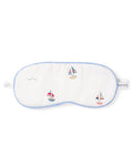 The Kids Twill Sleep Mask in Bateau by Petite Plume is a white luxury mask with blue trim, featuring small embroidered sailboats and waves. A PETITE tag on the right side makes it perfect for a matching set.