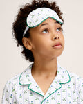 The Kid's Twill Sleep Mask in Fairway Stripe features a white design with green trim, decorated with golf clubs and flags. It includes an adjustable strap and a PETITE tag.