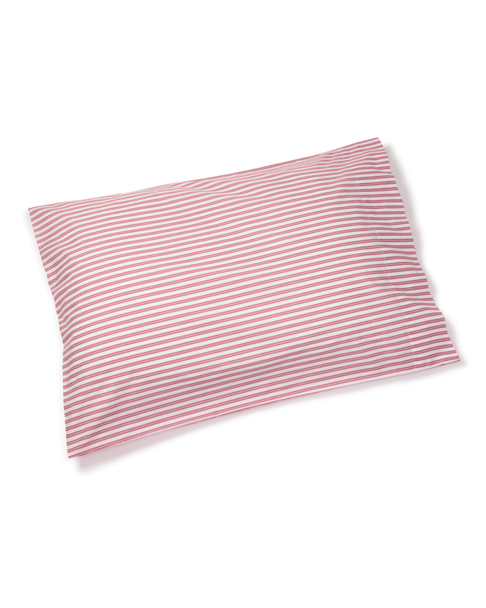 The Luxe Premium Cotton Bed Sheets in Antique Red Ticking by Petite Plume feature a striped pillow crafted from 100% cotton, with thin red and white lines. This soft piece complements luxury bedding and is showcased on a plain white background.