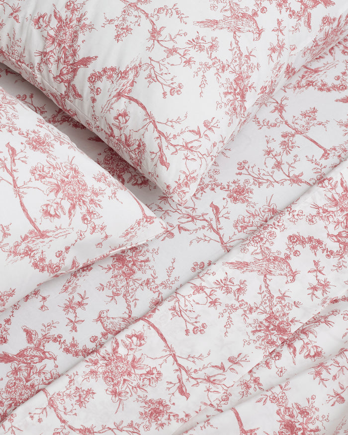 A neatly stacked set of Luxe Premium Percale Bed Sheets in Pink Timeless Toile, featuring two folded sheets and two pillowcases, displayed on a white background.