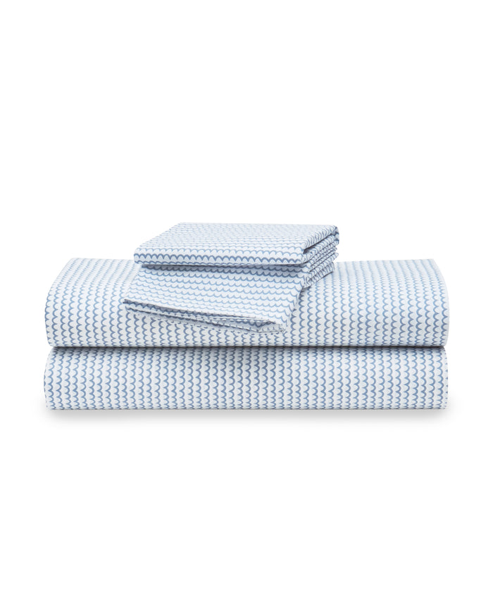 The Luxe Premium Cotton La Mer Bed Sheets by Petite Plume, featuring breathable blue and white percale sheets and pillowcases, are neatly stacked against a plain white background.