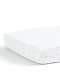A close-up of the Luxe Premium Percale Crib Sheet in Letters and Lullabies, featuring a white background adorned with small, light blue and yellow animal prints on a crib mattress.