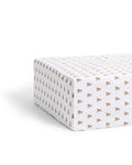 A close-up of the Luxe Premium Percale Crib Sheet in Teddy Tales, featuring a small repeating brown and orange floral pattern on white, smoothly wrapped around a mattress corner.