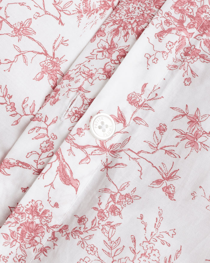 The Luxe Premium Percale Duvet Set in Pink Timeless Toile, featuring a folded duvet cover and two pillowcases with a white background and pink floral pattern, is stacked neatly on a white surface.