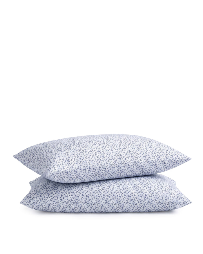 Two stacked Luxe Premium Percale Pillow Cases in Ditsy Waltz White, featuring a small, scattered blue floral pattern on crisp white fabric, displayed against a plain white background.