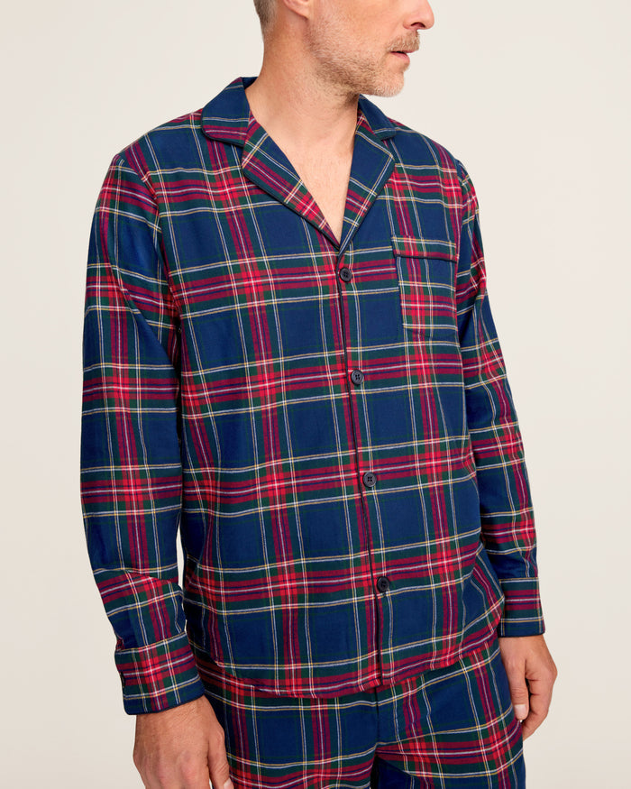 Close-up of a lightweight flannel plaid fabric with red, green, blue, and yellow stripes. The pattern is from Petite Plumes Mens Brushed Cotton Pajama Set in Windsor Tartan, featuring a notched lapel and a single black button.
