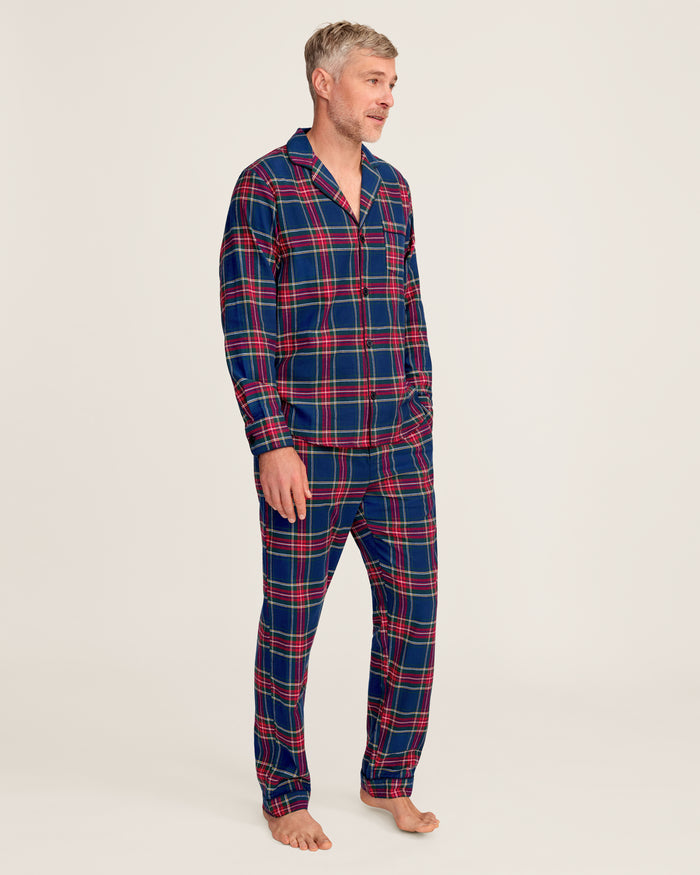 Close-up of a lightweight flannel plaid fabric with red, green, blue, and yellow stripes. The pattern is from Petite Plumes Mens Brushed Cotton Pajama Set in Windsor Tartan, featuring a notched lapel and a single black button.