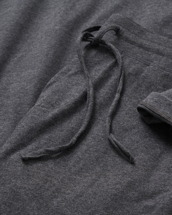 A close-up of Petite Plumes Mens Classic Pima Shorts in Dark Heather Grey shows their relaxed charm with a folded waistband and textured fabric, complemented by a casually draped yarn-dyed drawstring.
