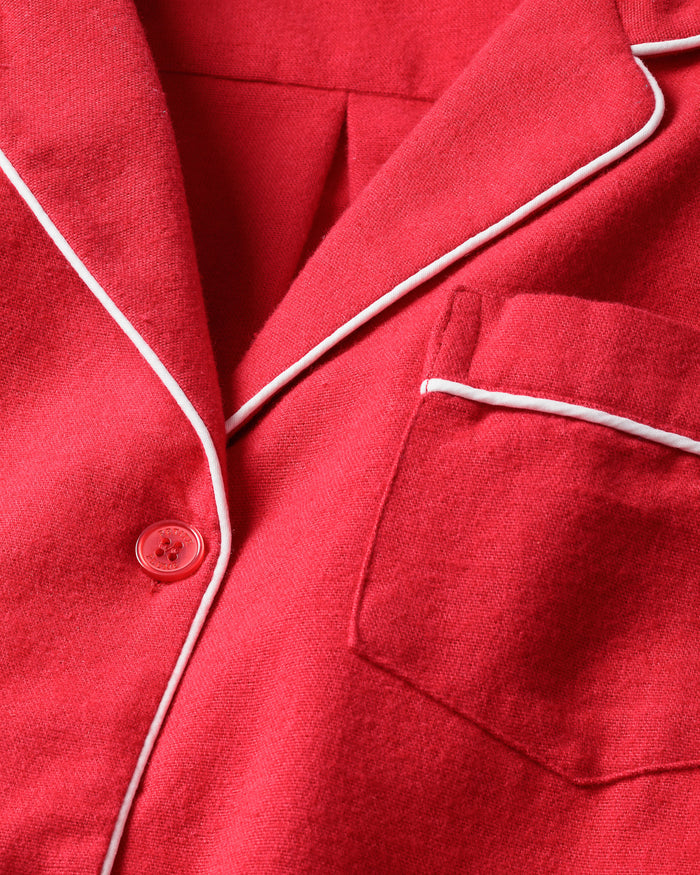 A close-up of Petite Plumes Mens Flannel Pajama Set in red shows 100% cotton fabric with white piping, featuring a button, pocket, and visible collar.