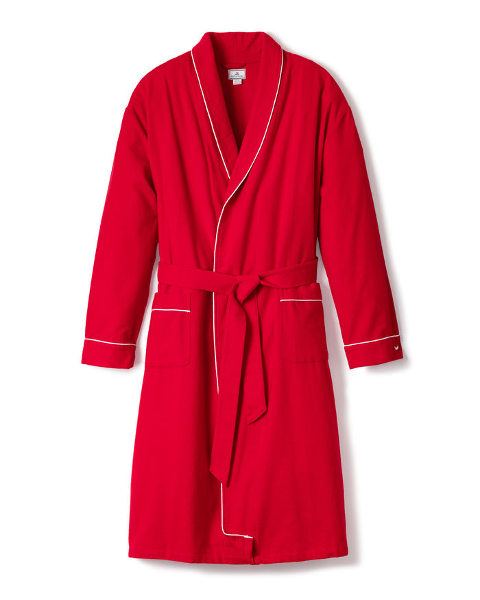 The Mens Flannel Robe by Petite Plume is a luxurious red bathrobe with white piping, featuring a shawl collar, waist tie, and two front pockets. The robe is showcased on a plain white background.