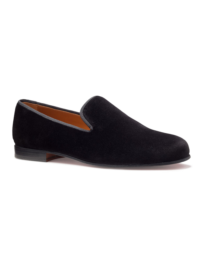 The Mens Hamptons Loafer in Black by Petite Plume features a classic silhouette and low heel, shown side view on a white background. Its refined elegance complements mens pajamas for an upscale, relaxed look.