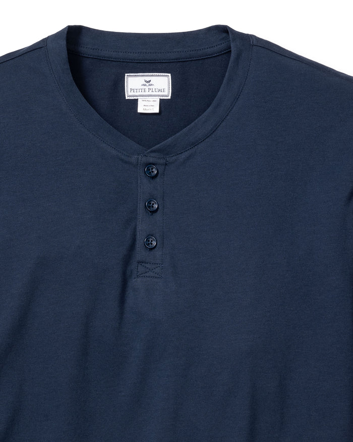 The Mens Pima Henley in Navy by Petite Plume features a soft Peruvian Pima cotton fabric and a classic three-button placket. Its simple design makes it an ideal addition to your bedtime routine, displayed on a white background for clarity.