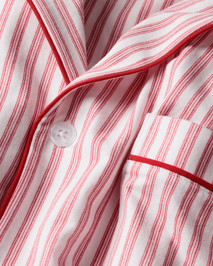 This close-up features the Mens Pima Pajama Top by Petite Plume in Antique Red Ticking. The luxurious yarn-dyed Peruvian Pima cotton showcases vertical red and white stripes with a visible button and pocket outlined in red piping, ensuring softness and comfort for restful nights.