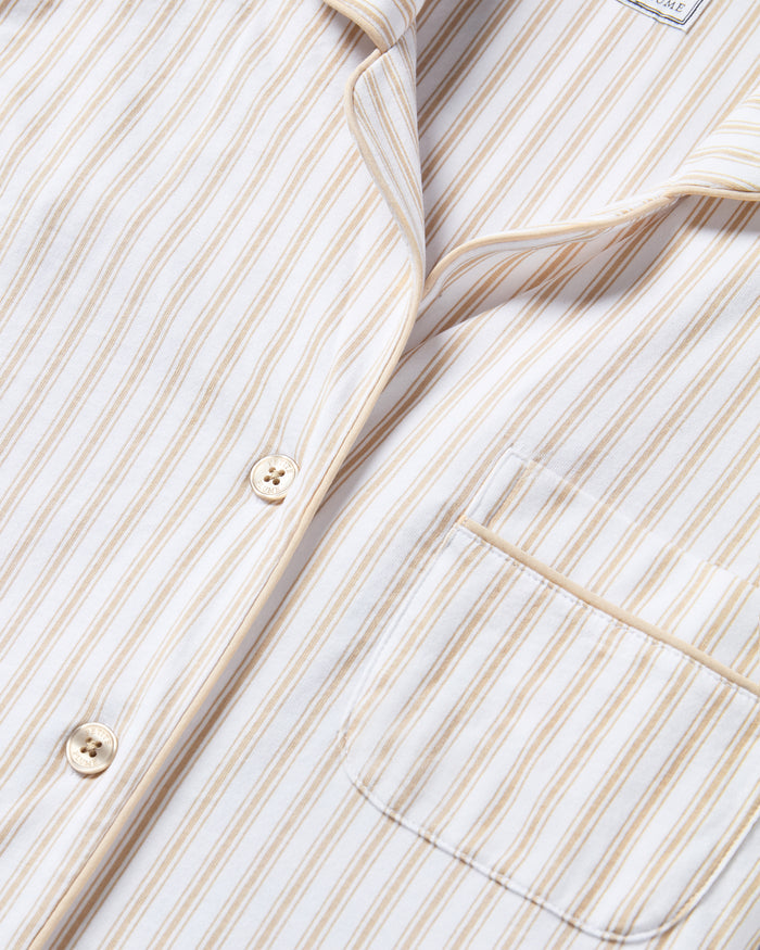 The Men's Pima Pajama Set in Camel Ticking features beige and white stripes, a button-up long-sleeve top with a chest pocket, and matching drawstring pants, displayed flat on a white background.