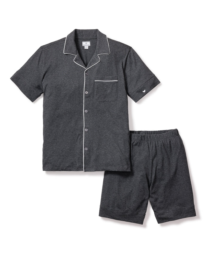 The Mens Pima Pajama Short Set in Dark Heather Grey by Petite Plume is made from soft jersey knit. It features a short-sleeve button-up top with a chest pocket and white piping, paired with shorts that have an elastic waistband for comfort, crafted from quality yarn-dyed fabric.