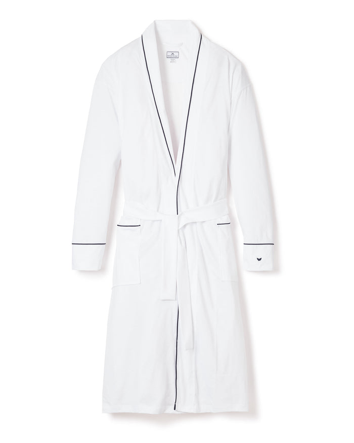 The Mens Pima Robe by Petite Plume, in white with navy piping, features long sleeves and a waist tie belt. Made from luxurious Peruvian Pima cotton, it offers exceptional softness and comfort. It includes two front pockets accented with navy trim.
