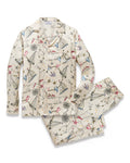Men’s Silk Pajama Set in Regatta Royale, featuring a cream base adorned with whimsical sailboats, compasses, and nautical motifs in blue, red, and black. The set includes a long-sleeve button-up top and matching pants laid flat.