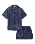 Men’s Silk Pajama Short Set in Nautical Knots features a navy blue short-sleeve button-up shirt with a chest pocket and white vertical stripe pattern, paired with matching shorts that have an elastic waistband.