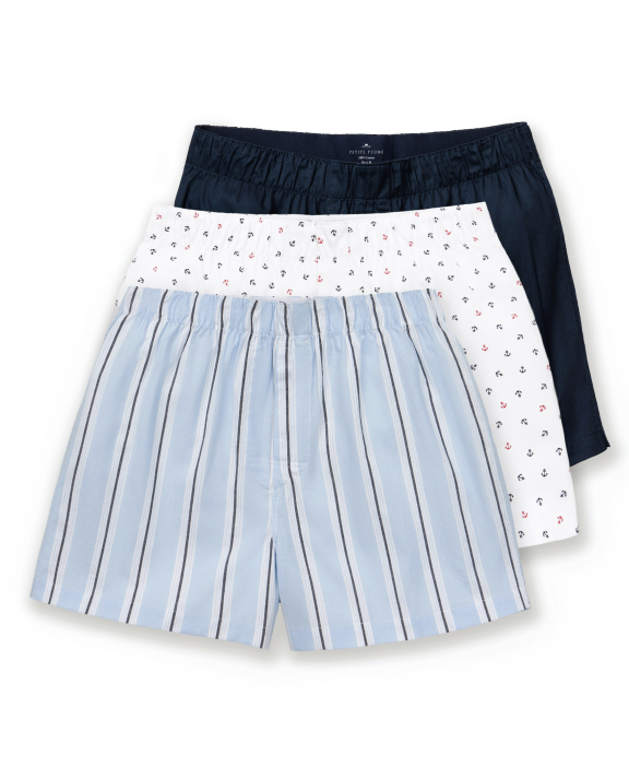 The Men’s Twill 3 Pack Boxers in Coastal Stripe, Anchors Away, and Navy are displayed overlapping on a white background, featuring one solid navy pair, one pair with small anchor prints on white, and one light blue pair with vertical white and navy stripes.