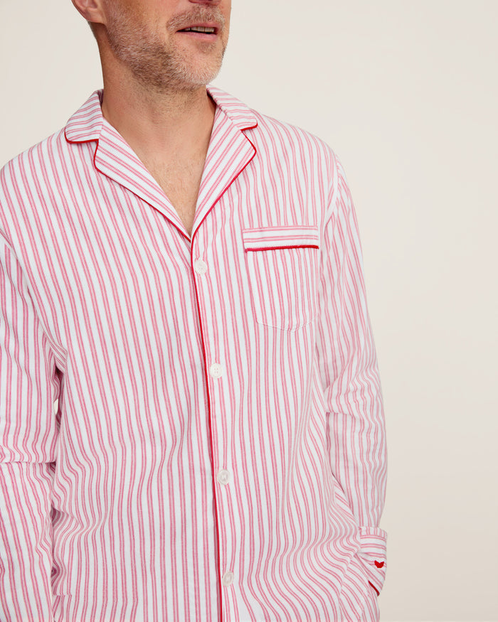 Close-up of Petite Plumes Mens Twill Pajama Set in Antique Red Ticking, featuring pink and white vertical stripes, a collar, a pocket with matching trim, and a single white button. Perfect for cozy relaxation.