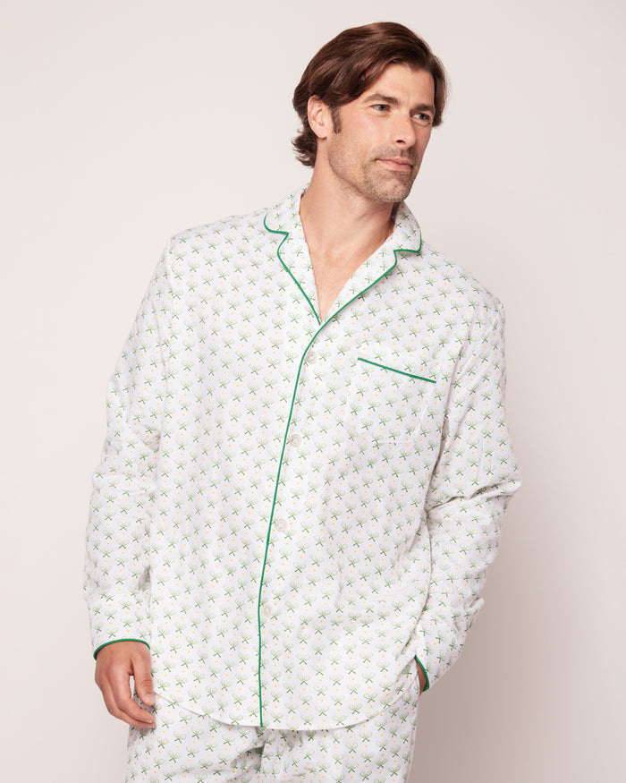 A person wears the Mens Twill Pajama Set in Match Point by Petite Plume, made from premium cotton with a small green floral pattern. The button-up shirt includes green piping and a chest pocket, combining comfort and style against a plain backdrop.