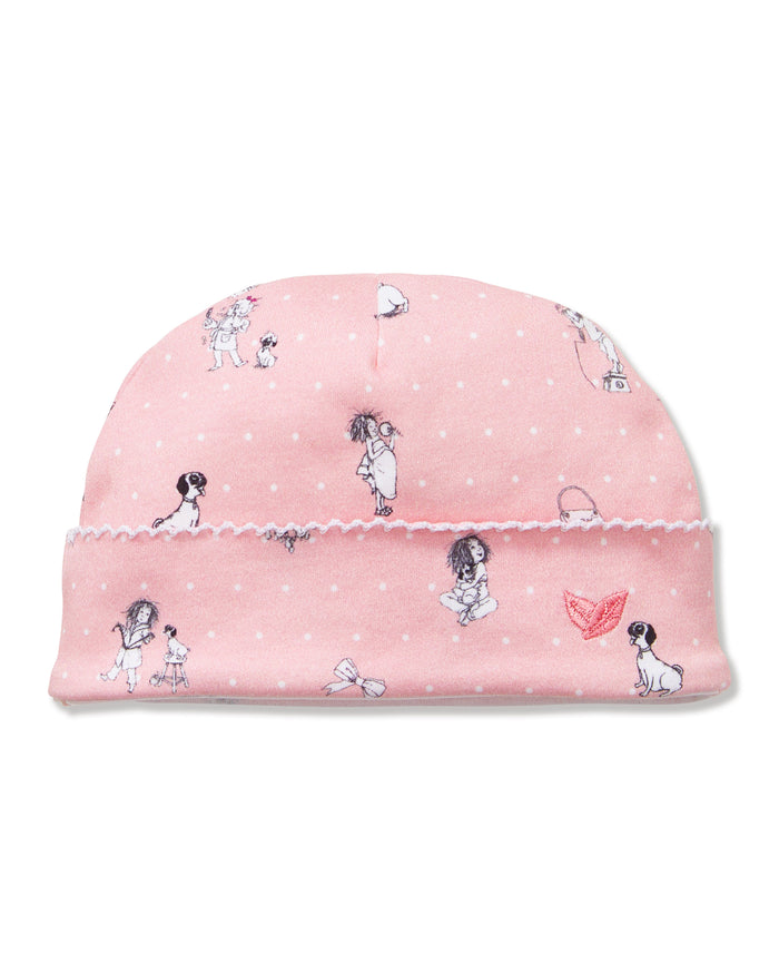 The Petite Plume x Eloise Baby Pima Hat in Eloise Adventures features soft pink fabric with white polka dots, playful girl and dog illustrations, and a pink embroidered butterfly on the cuff.
