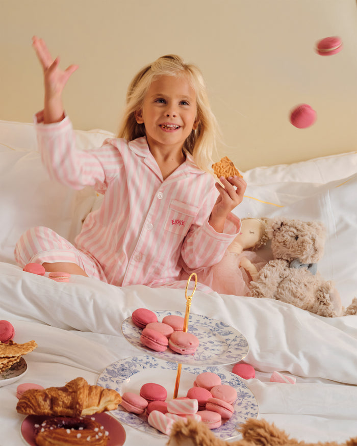 Petite Plume x Eloise Kid's Twill Pajama Set in Eloise Classic Stripe features pink and white stripes.