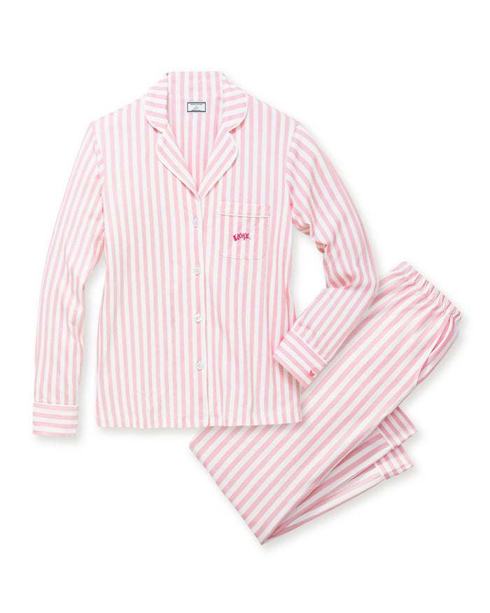 The Petite Plume x Eloise Women's Pima Pajama Set in Eloise Classic Stripe features pink and white vertical stripes, a long-sleeve button-up top with a collar, chest pocket with red embroidery, and matching pants.