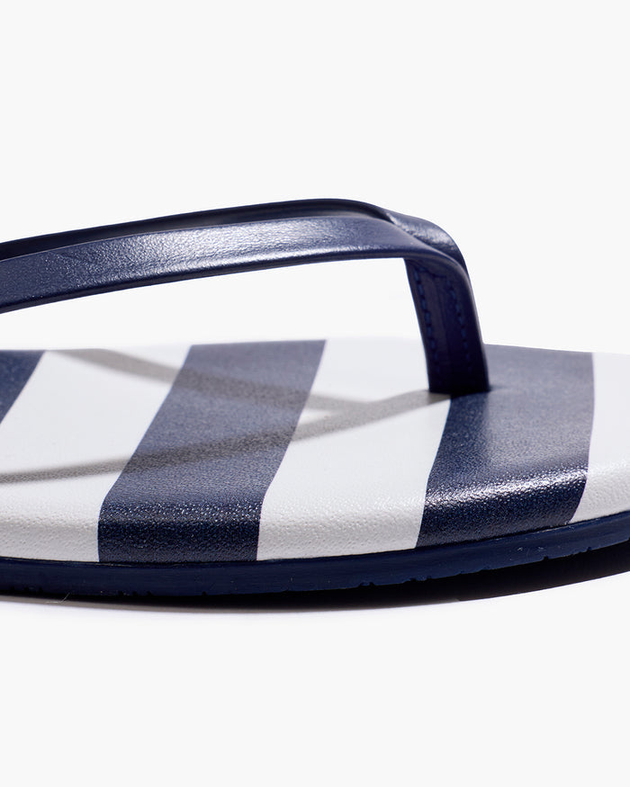 The Petite Plume x TKEES Lily Sandal in Cabana Stripe features navy blue and white horizontal stripes on the footbed with navy straps, shown side by side on a white background.