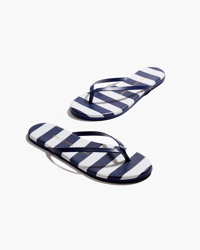 The Petite Plume x TKEES Lily Sandal in Cabana Stripe features navy blue and white horizontal stripes on the footbed with navy straps, shown side by side on a white background.