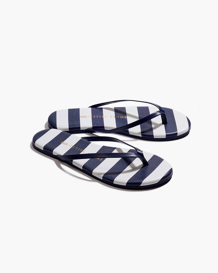 The Petite Plume x TKEES Lily Sandal in Cabana Stripe features navy blue and white horizontal stripes on the footbed with navy straps, shown side by side on a white background.