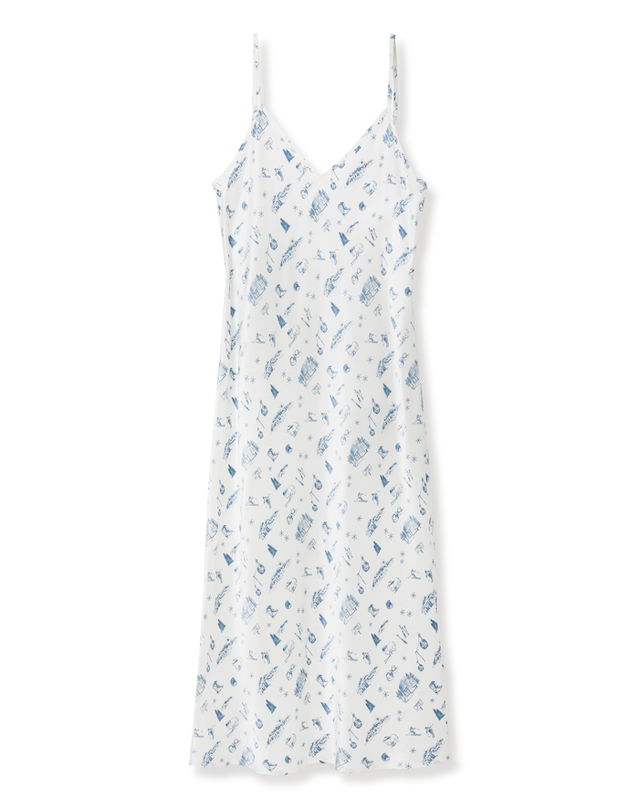 Petite Plume x White Elephant Women’s Silk Cosette Nightgown: A white, knee-length nightgown with thin straps and a V-neckline, adorned with a scattered blue print of various small objects. This nightgown features a relaxed, loose fit for added comfort.