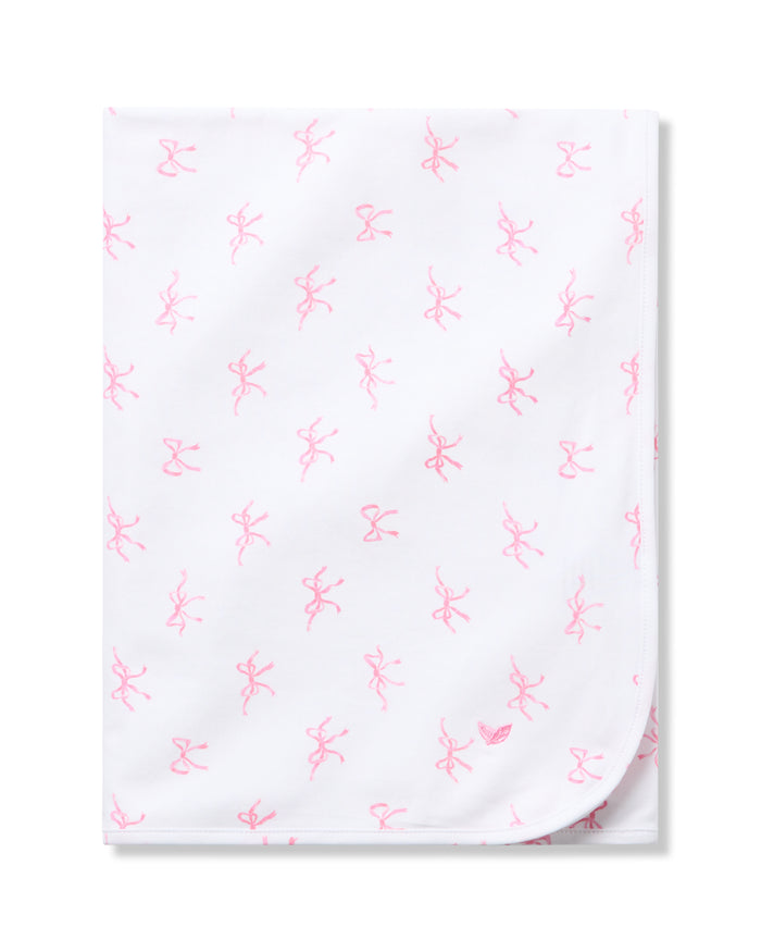 The Petite Plume Pima Baby Blanket in Blushing Bows is crafted from luxurious Peruvian Pima Cotton and features a charming pattern of small pink ballet dancers and bows. Its neatly folded design with visible rounded corners brings elegance to any nursery.
