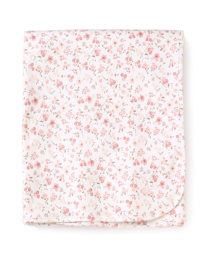 The Pima Baby Blanket in Dorset Floral by Petite Plume is crafted from folded Peruvian Pima Cotton with a delicate pink floral pattern, showcasing small flowers and thin green stems. It makes for a luxurious baby blanket.