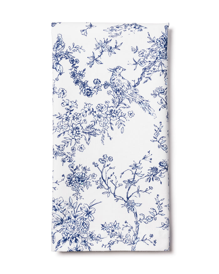 The Signature Twill Napkin in Timeless Toile by Petite Plume is crafted from white cotton, displaying an intricate blue toile de Jouy pattern with birds and flowering branches, ideal for adding a classic and vintage touch to elegant table linens.