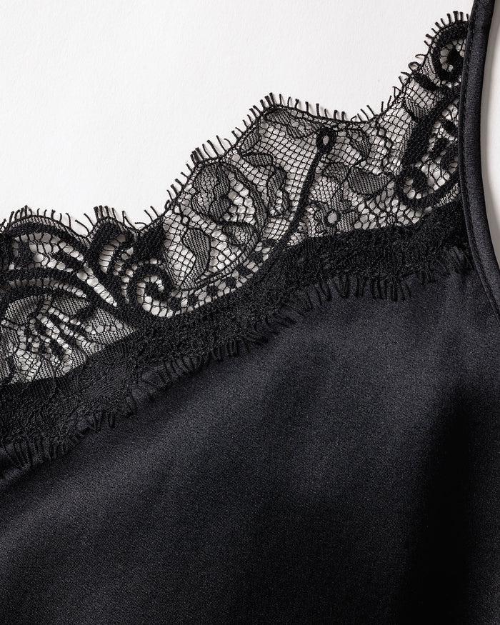 Close-up of the Womens Silk Lace Cami Short Set in Black by Petite Plume, showcasing black, silky luxury sleepwear with intricate floral lace detailing along the edge for an elegant and delicate touch to this machine-washable silk garment.