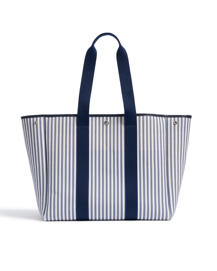 The Beckett Canvas Tote Bag in Navy French Ticking is a spacious tote with vertical blue and white stripes, two long navy handles, and a structured, open-top design.