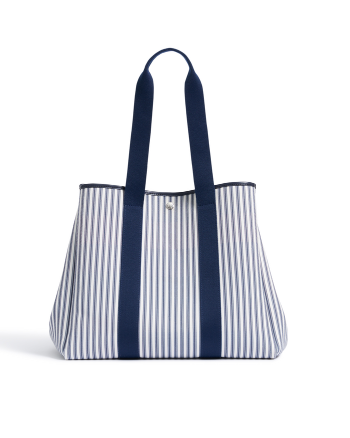 The Beckett Canvas Tote Bag in Navy French Ticking, featuring blue and white stripes, two long navy handles, and a structured shape, photographed on a white background.